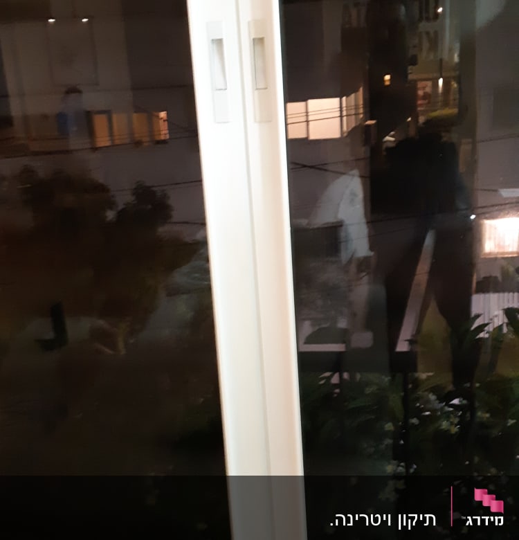 תריסים לבנים על חלון זכוכית בלילה